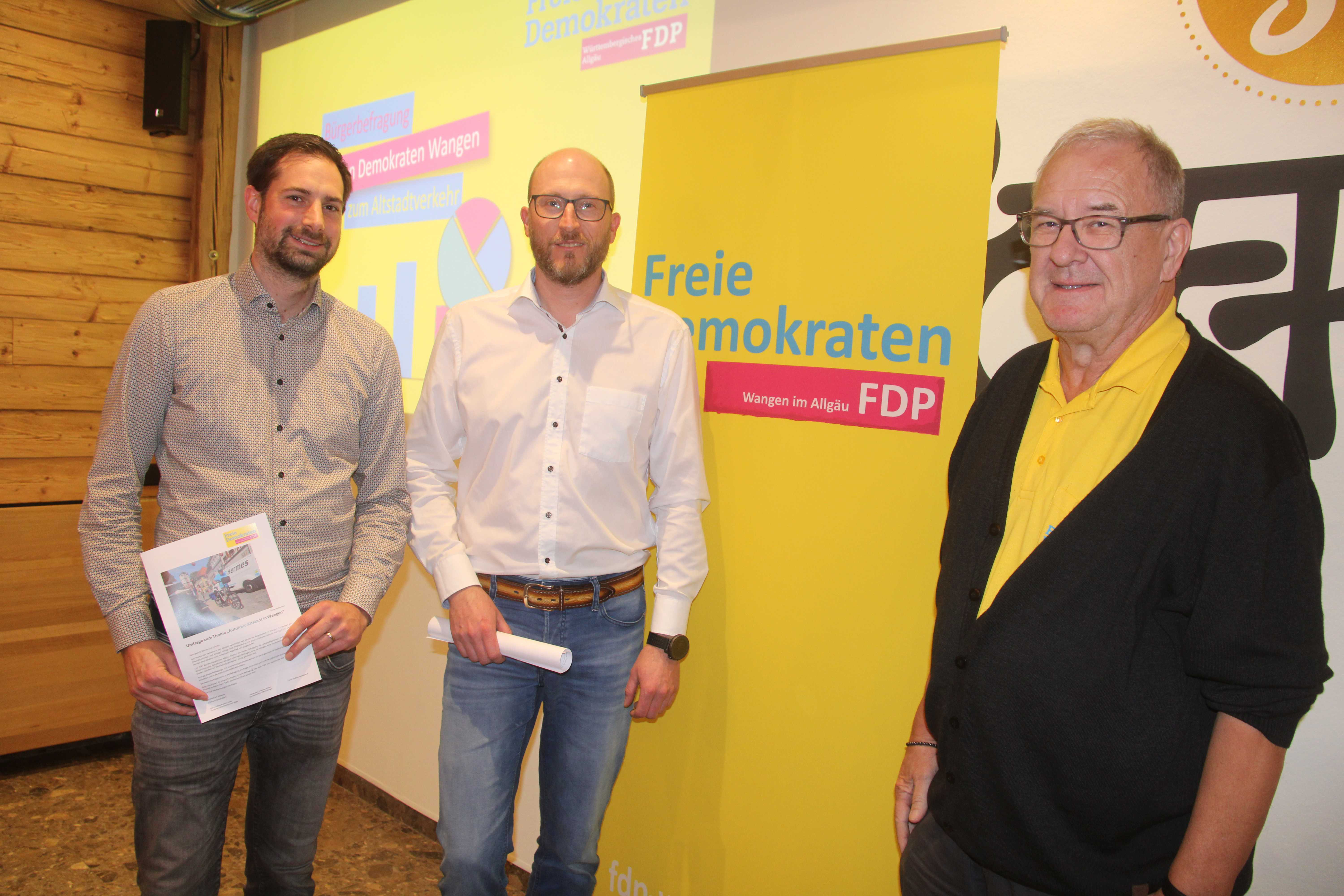 Das Projektteam bei der Vorstellung der Ergebnisse: Stephan Bulmer (stellv. Ortsvorsitzender), Sebastian Scherer (Ortsvorsitzender der FDP Württembergisches Allgäu) und FDP-Stadtrat Frank Scharr (v.l.n.r.) vor einem gelben FDP-Banner.
